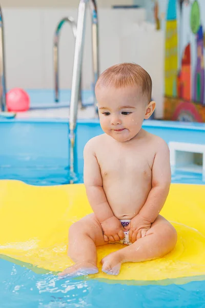 Swimming lessons for children. A little boy is learning to swim in a baby pool. Children's development. First swimming lessons for children