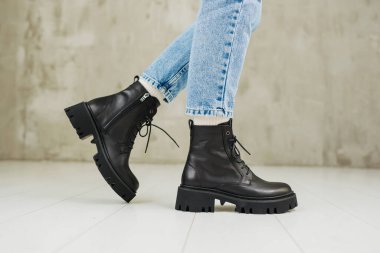 Kotlu kadın bacakları ve siyah deri çizmeleri. Kadın kış ayakkabıları.