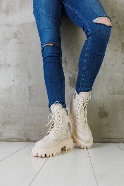 Kotlu kadın bacakları ve doğal deriden yapılmış beyaz deri çizmeler. Bir kadın bahar modern ayakkabısı koleksiyonu.