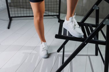 Beyaz klasik spor ayakkabılar içinde mükemmel kadın bacakları. Beyaz ayakkabılar içinde güzel kadın bacakları.