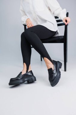 Siyah deri ayakkabılar ve siyah taytlar içinde güzel kadın bacakları. Yaz kadın ayakkabıları.