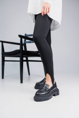 Siyah deri ayakkabılar ve siyah taytlar içinde güzel kadın bacakları. Yaz kadın ayakkabıları.