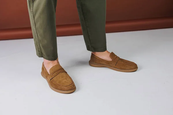 Male feet in brown suede casual shoes. Men\'s fashionable shoes