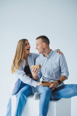 Beyaz gömlek, kot pantolon ve izole beyaz arka plan giyen mutlu çift kavramı. Bir erkek ve bir kadın beyaz bir arka planda sarılıyorlar. Sevinç duyguları.