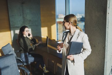 Smiling positive diverse colleagues in casual clothes working on a new project sitting together at the negotiation table during a meeting in a bright creative workspace