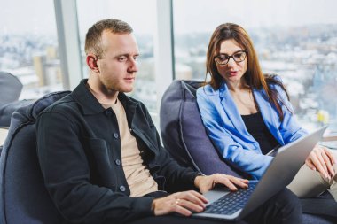 Two business people working remotely online using a laptop. Colleagues work remotely in the workspace.