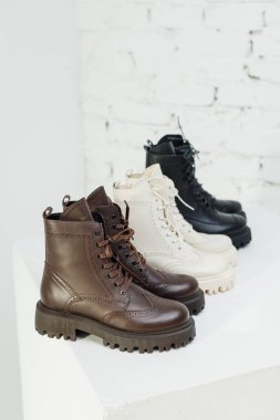 Stylish women's leather brown boots on white background, women's spring shoes close-up. Fashionable boots for women. Selective focus