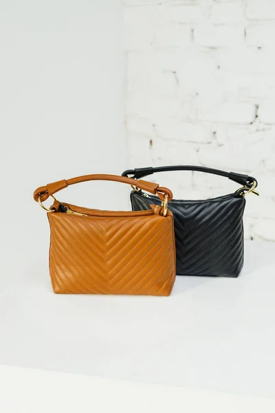 Brown and black women's casual bag made of eco-leather close-up. Women's leather bag