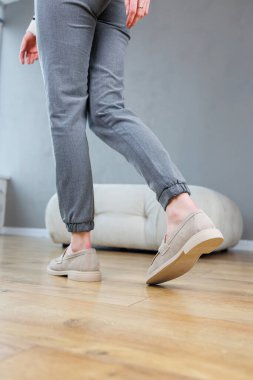 Female legs close-up in gray shoes without heels. Women's comfortable summer casual shoes. Gray women's spring shoes