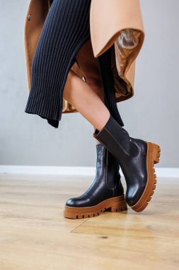 Close-up of female legs in black leather chelsea boots. Women's comfortable spring casual shoes. Black women's spring chelsea boots