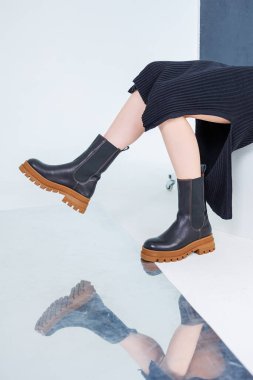 Close-up of female legs in black leather chelsea boots. Women's comfortable spring casual shoes. Black women's spring chelsea boots