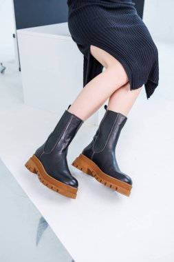 Close-up of female legs in black leather chelsea boots. Women's comfortable spring casual shoes. Black women's spring chelsea boots