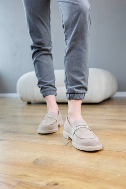 Female legs close-up in gray shoes without heels. Women's comfortable summer casual shoes. Gray women's spring shoes