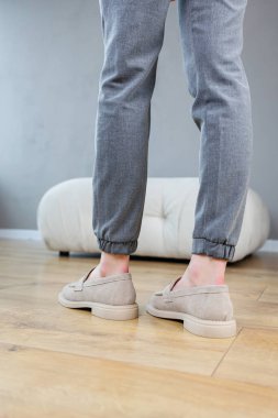 Female legs close-up in gray shoes without heels. Women's comfortable summer casual shoes. Gray women's spring shoes