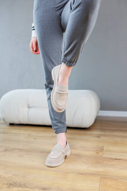 Female legs close-up in gray shoes without heels. Women's comfortable summer casual shoes. Gray women's spring shoes