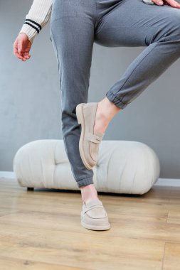 Female legs close-up in gray shoes without heels. Women's comfortable summer casual shoes. Gray women's spring shoes