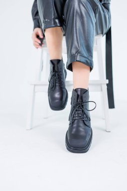 Female legs in leather pants and black leather boots. Women's casual leather spring boots. Stylish shoes for women