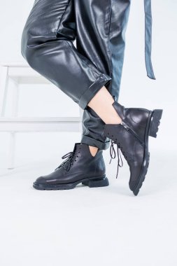 Female legs in leather pants and black leather boots. Women's casual leather spring boots. Stylish shoes for women