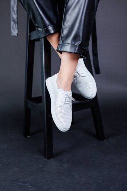 Female legs in leather pants and black leather boots. Women's casual leather spring boots. Stylish shoes for women