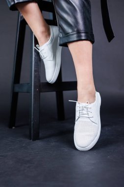 Female legs in leather pants and black leather boots. Women's casual leather spring boots. Stylish shoes for women