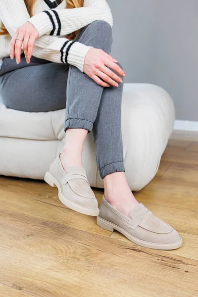 Female legs close-up in gray shoes without heels. Women's comfortable summer casual shoes. Gray women's spring shoes