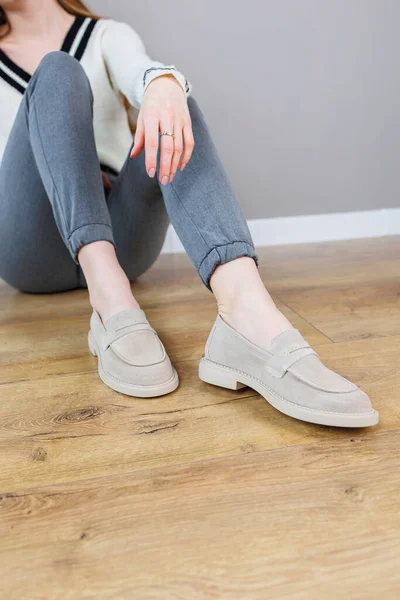 Female legs close-up in gray shoes without heels. Women\'s comfortable summer casual shoes. Gray women\'s spring shoes