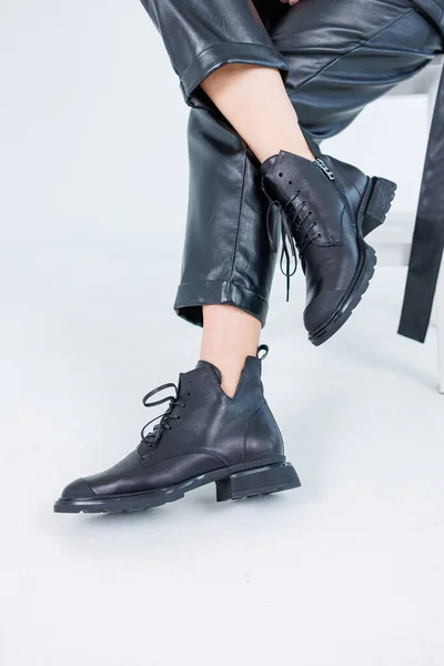 Female legs in leather pants and black leather boots. Women\'s casual leather spring boots. Stylish shoes for women