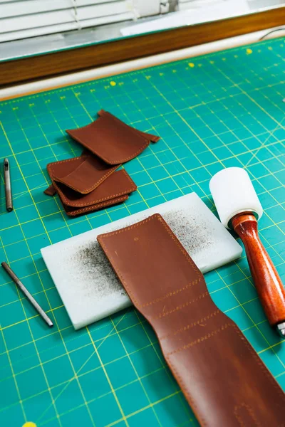Tools for making leather goods and pieces of brown leather. Production of leather products. View from above