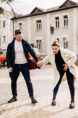 Birbirine aşık genç bir çift sokakta yürüyor ve temiz havanın tadını çıkarıyor. Mutlu evli bir çift. Şık bir çift, bir erkek ve bir kadın.