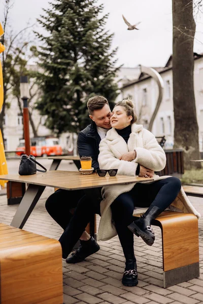 幸福的年轻夫妇穿着外套坐在外面的桌子旁喝咖啡 在露天休憩 — 图库照片