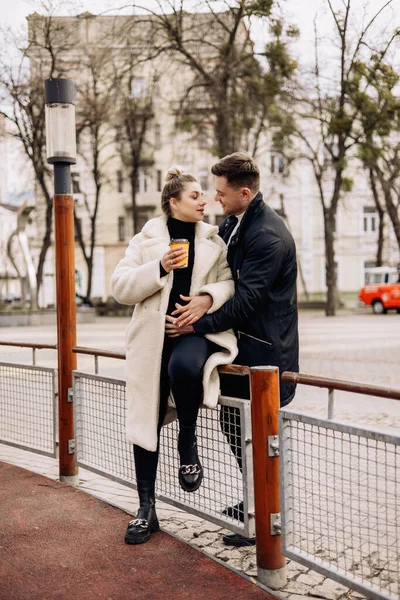 通りを歩いてコーヒーを飲むアウターを愛する幸せな若いカップル 野外でのレクリエーション 若い夫婦が — ストック写真