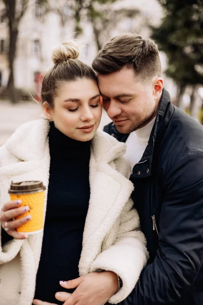 幸福的年轻夫妇穿着外衣在街上散步 喝咖啡 在露天休憩 一对年轻夫妇 — 图库照片