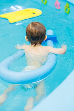 Küçük çocuk 2 yaşında havuzda. Küçük çocuklar için yüzme dersleri.