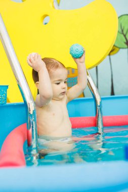 Küçük çocuk 2 yaşında havuzda. Küçük çocuklar için yüzme dersleri.