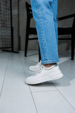 Beyaz şık ayakkabılı kadın bacakları. Sıradan kadın modası. Kadınlar için rahat ayakkabılar. Kadınların rahat yaz ayakkabıları..