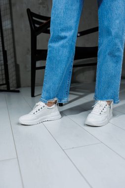 Beyaz şık ayakkabılı kadın bacakları. Sıradan kadın modası. Kadınlar için rahat ayakkabılar. Kadınların rahat yaz ayakkabıları..
