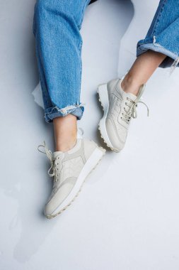 Kotlu kadın bacakları ve şık beyaz ayakkabılar. Sıradan kadın modası. Kadınlar için rahat ayakkabılar. Kadınların rahat yaz ayakkabıları..