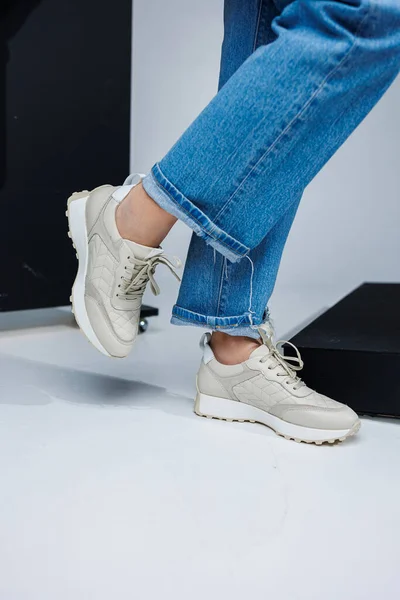 Primer Plano Las Piernas Femeninas Jeans Zapatillas Blancas Con Estilo — Foto de Stock