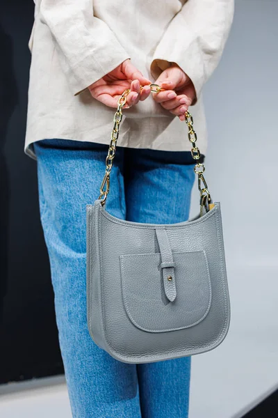 Women's leather stylish handbag. A blue everyday bag in a woman's hands.