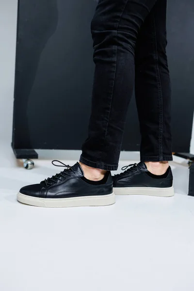 stock image Close-up of male legs in black leather casual sneakers. Comfortable men's demi-season shoes