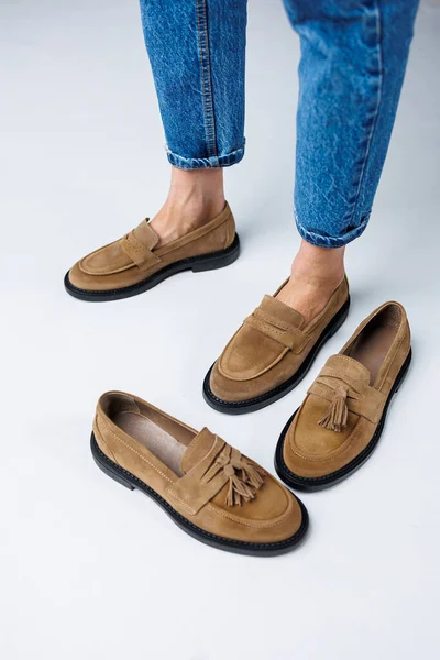 Casual women\'s fashion. Classic shoes for women. Slender female legs in trousers and brown stylish casual loafers. Women\'s comfortable summer shoes.