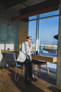 Ofis işleri, ofiste çalışan çekici genç bayan yöneticiler modern dizüstü bilgisayarla parlak çalışma alanları, lezzetli kahve içen genç kadınlar.