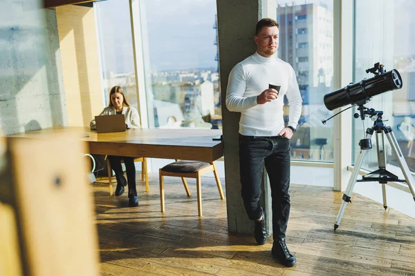 프리랜서는 공간에 원격으로 일하면서 커피를 마십니다 스웨터를 바지를 사무실에서 행복하게 — 스톡 사진