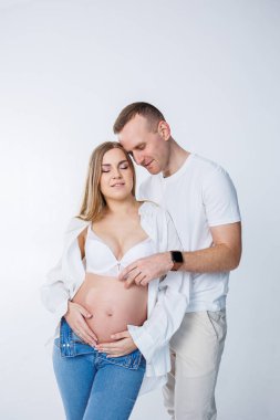 Bir erkek hamile bir kadına sarılır ve karnını okşarsa mutlu genç bir çift hamile kalır..