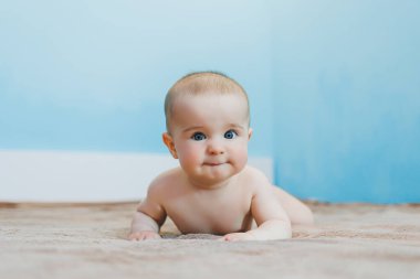 Küçük şirin bebek karnının üstünde yatar ve başını tutar, çocuk gelişimi.