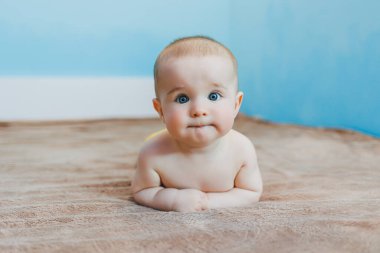 Küçük şirin bebek karnının üstünde yatar ve başını tutar, çocuk gelişimi.