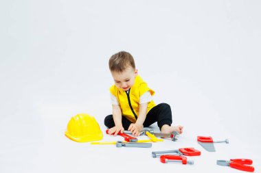 İki yaşında bir çocuk plastik inşaat aletleriyle oynuyor. Çocuk plastik oyuncakları. Çocuk inşaatçısı seti..