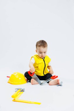 İki yaşında bir çocuk plastik inşaat aletleriyle oynuyor. Çocuk plastik oyuncakları. Çocuk inşaatçısı seti..
