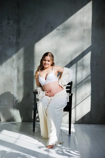 Una Mujer Guapa Embarazada Con Traje Blanco Sujetador Está Sentada — Foto de Stock