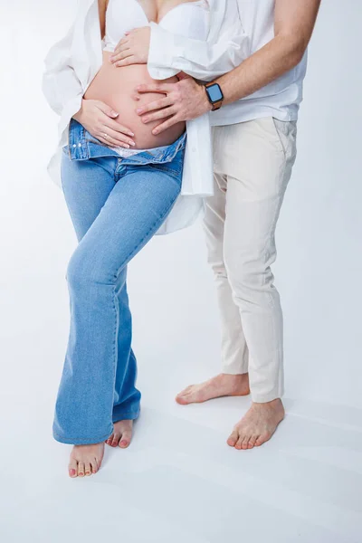 幸せな夫婦 妊娠中の女性と愛する男は白い背景に彼女の腹を抱いています 妊娠中の女性の腹にカップルとしての赤ちゃんの動きの感覚 — ストック写真